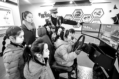 山東省榮成市公安局道路交通安全宣傳教育基地,交警帶領小學生現場體驗模擬駕駛。新華社發